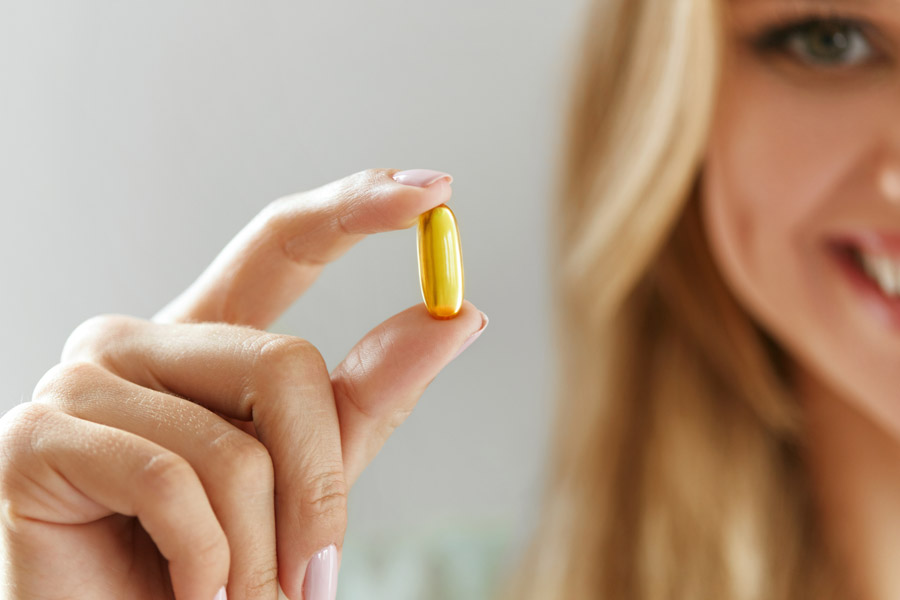 Woman Holding Fish Oil Pill