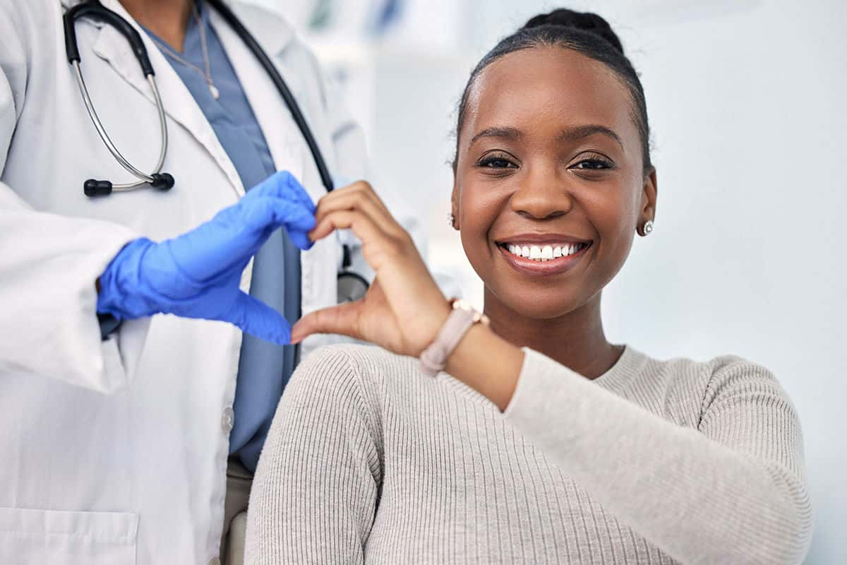 patient and a doctor forming a heart shape with their hands